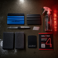 HMU4TINT DIY Window Tint Tool Kit — blue and black squeegees, precision knife with blades, microfiber cloths, heat card, HMU4TINT spray bottle, and printed install guide laid out flat under HMU4TINT neon