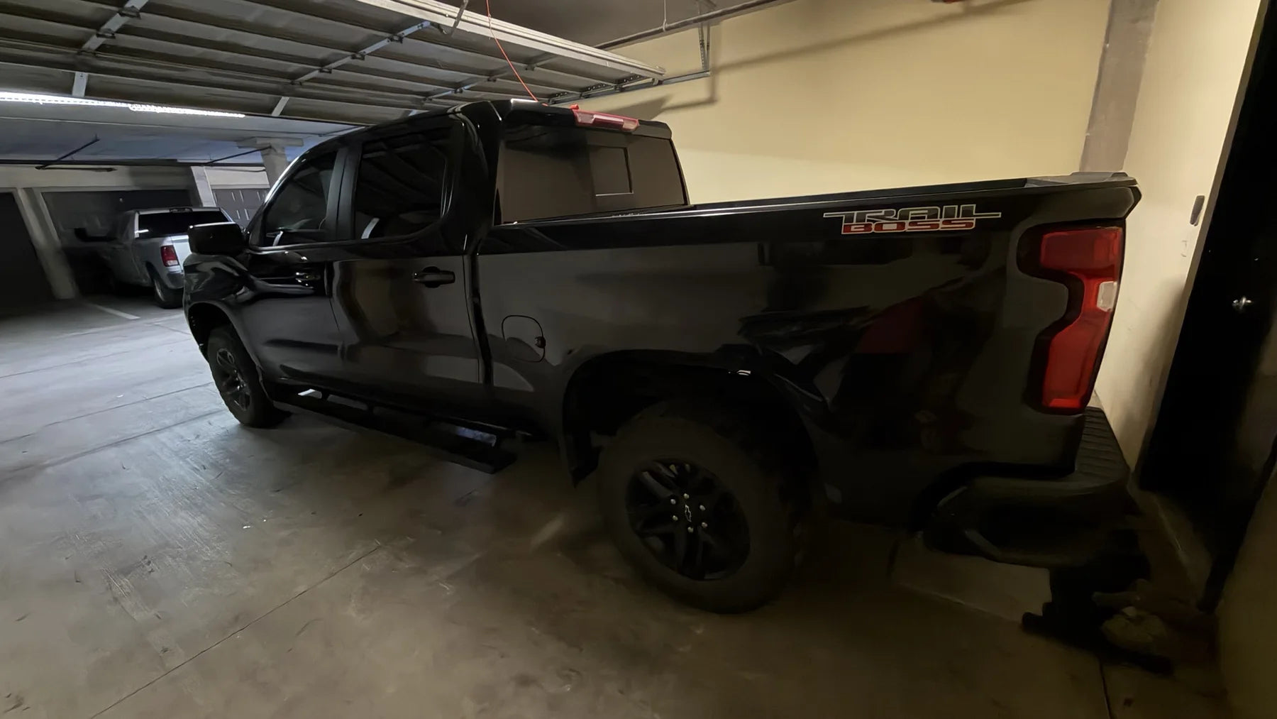 Rear three-quarter view of a black Chevrolet Silverado Trail Boss with 5 percent rear tint